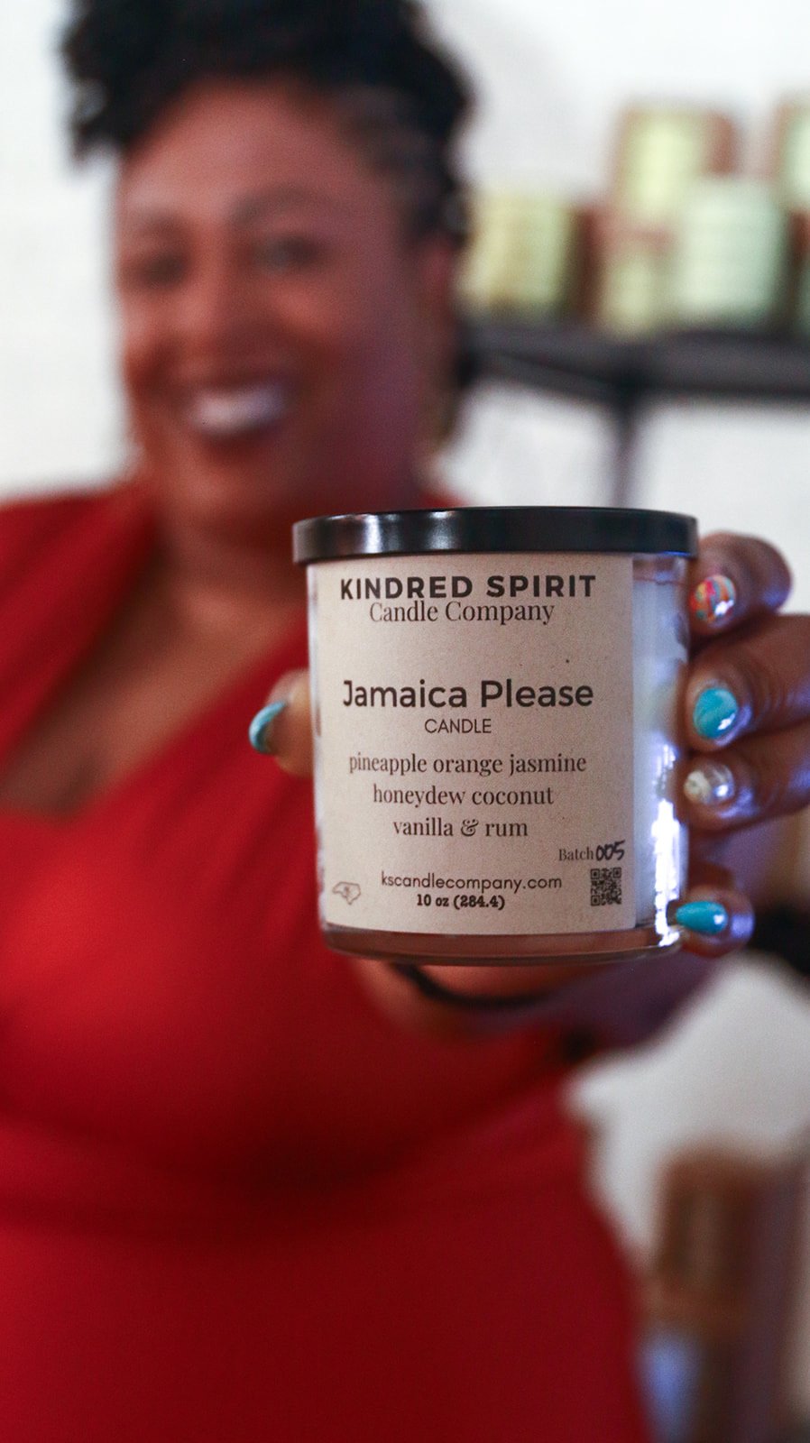 Monique Mackey of Kindred Spirit stands in front of a display of handcrafted candles and home goods at Boxyard RTP pop-up shop.